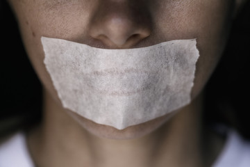 Censorship in the Modern World: A man's mouth sealed with an adhesive tape, close-up