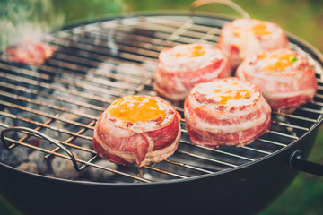 Making home made Beer Can Bacon Burgers on barbecue grill.