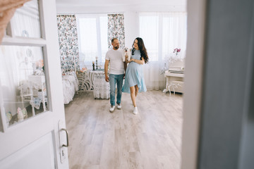 Young couple expecting baby standing together indoors