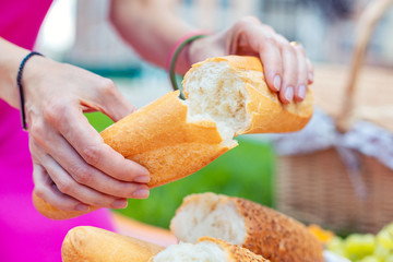 Freshly baked. Selective focus of a loaf of bread being torn in two pieces