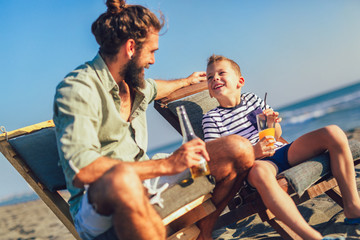 Father and son having fun at beach together portrait fun happy lifestyle