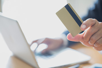 Businessmen holding credit cards print details online shopping, Hands holding credit card and using laptop.