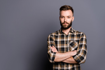 Fototapeta premium Strong, confident, strict man in casual checkered shirt cross ar