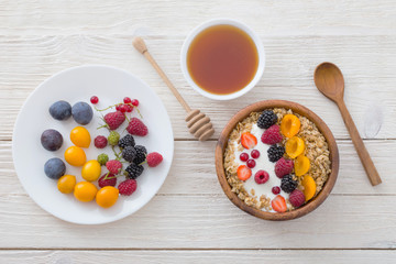 granola with berries on white wooden background