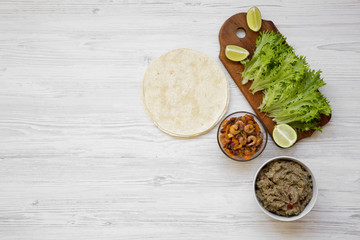 Shrimp taco ingredients on white wooden table, top view. Flat lay, from above, overhead view. Copy space.