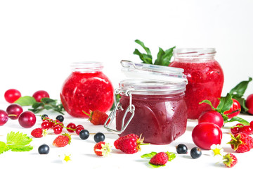 homemade jam in a glass jar of various berries and plums on a light background.Healthy food, diet, detox, clean eating and vegetarian concept with copy space.