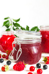 homemade jam in a glass jar of various berries and plums on a light background.Healthy food, diet, detox, clean eating and vegetarian concept with copy space.