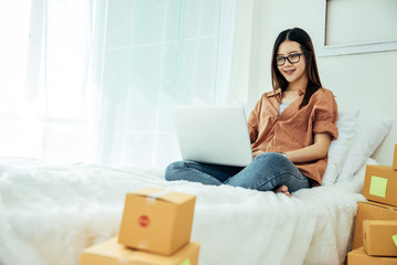 Young asian girl is freelancer with her private business at home office, working with laptop, coffee, online marketing. Young woman startup her SME business.