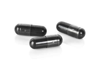 Charcoal capsules isolated on white background.