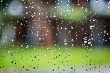 Water droplets on glass with green bokeh