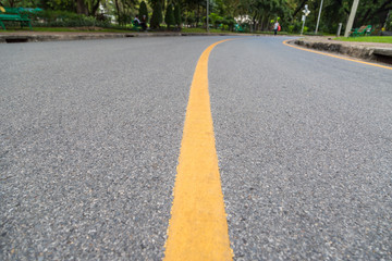 Close up of yellow line  on the public park with people exercise and cycling for good health background