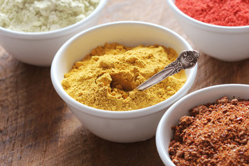 Turmeric powder.Various colorful spices on wooden table in bowls . Food and cuisine ingredients.