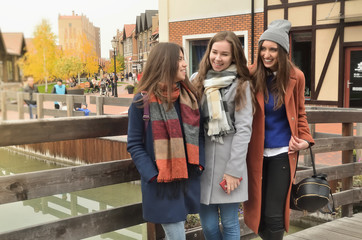 Three girls on the bridge standing and laughing