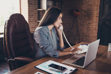 Intelligent accountant lady in loft workplace dials a phone numb