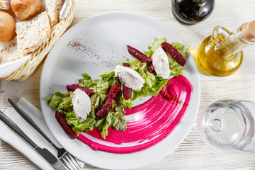 Healthy italian salad with beetroot, lettuce leaves and cheese feta and dressing with oil and mustard seeds.