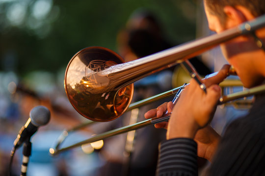 The trumpeter is playing on the trumpet. Concert activity in the open air.