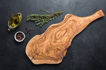 Olive wood cutting board, spices and herbs for cooking. Food background with copy space for text, recipe, greeting, advertising - obrazy, fototapety, plakaty