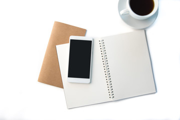 Top view over the working desk with opened notebook in the middle. Copy space for text. Flat lay of a workplace contains notebooks, cup of coffee and phone. White background