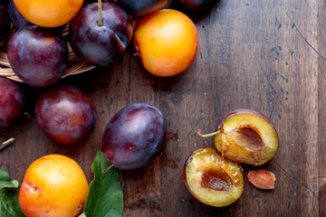 Ripe juicy plums on a wooden background.