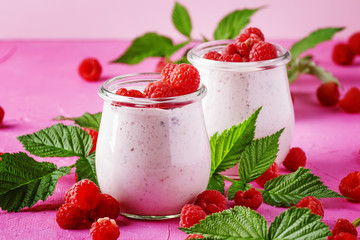 Raspberry smoothie in glass jar with fresh berry and greek yogurt on pink stone background, selective focus - obrazy, fototapety, plakaty