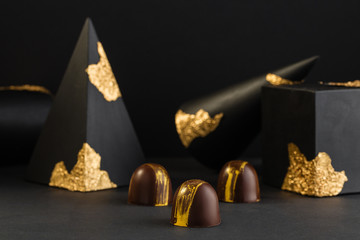 Luxury bonbons painted with gold on black background