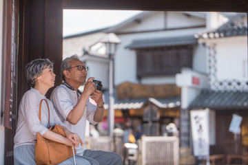 旅先でカメラを構えるシニア夫婦