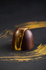 Luxury bonbons painted with gold on black background