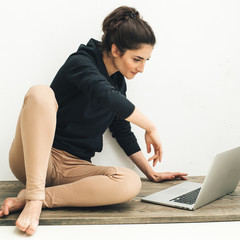 Naklejka premium Young beautiful woman with laptop notebook on floor home surfing internet 