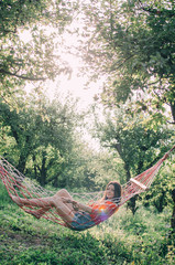 Close up view of Woman relaxing in hammock in the garden