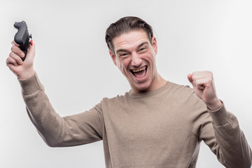 Winning game. Mature man with facial wrinkles feeling happy after winning video game on image...