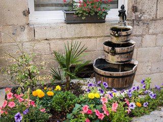 Small flowerbed in front of a window with a fountain