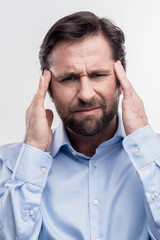 Unexpected headache. Image without face retouching with handsome mature bearded office worker...