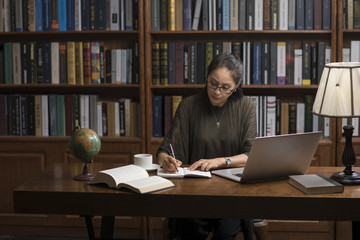 Elegant mature woman using laptop in study