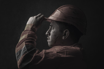 dramatic portrait of tired rail worker who hold his safety helmet