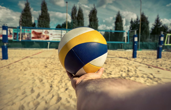 Beach Volleyball ball in hand before start the game under sunlight