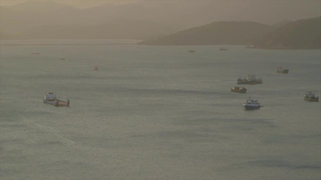 A zoomed in long shot of cargo ships in the ocean.