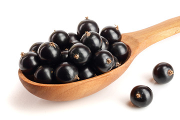 black currant heap in wooden spoon isolated on white background