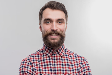 Obraz premium Handsome man. Image without face retouching with handsome dark-haired bearded man wearing bright squared shirt