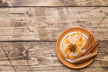 Christmas concept. tangerines and cinnamon sticks with anise and nuts on wooden background.