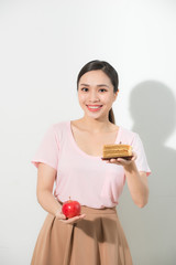 The girl in one hand has an apple, in the other hand a cake.