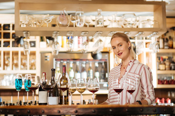 Wine bar. Beautiful attractive woman standing at the counter while being ready to taste the wine
