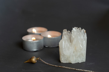 Pendulum, transparent quartz and candles