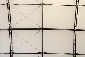 A ceiling of a street scene from a metal frame on a background of a light canvas. The construction of the roof of the metal frame scene. Cables and frame. Installation and assembly of the pedestal.