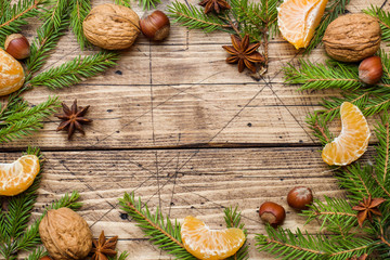 Christmas concept. tangerines and cinnamon sticks with anise and nuts on wooden background.