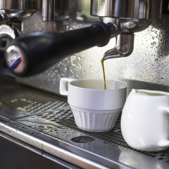 A coffee machine prepares two espresso in two glass cups in a cafe. The work of the coffee machine. Culture of coffee making in the city