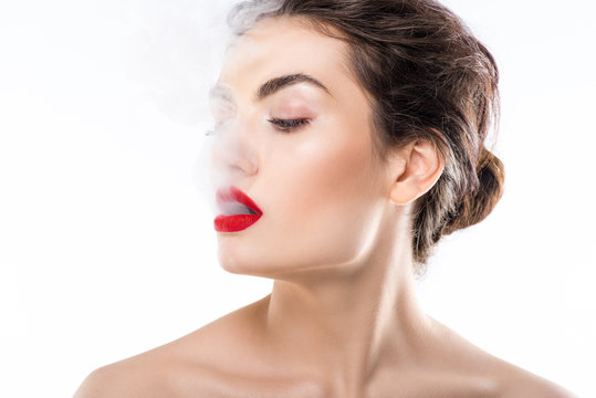 beautiful fashionable woman blowing smoke, isolated on white