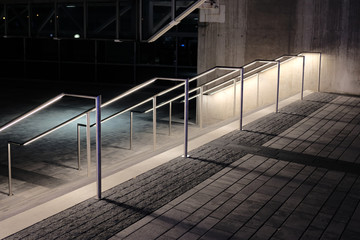 Stair rails in city illuminated at night