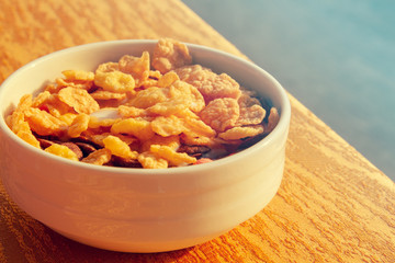 Delicious corn and oat flakes with milk for breakfast in a white ceramic plate. A useful morning breakfast. Useful food, giving energy in the morning.