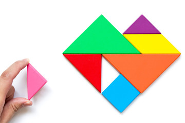 Color wood tangram puzzle in heart shape wait to fulfill on white background