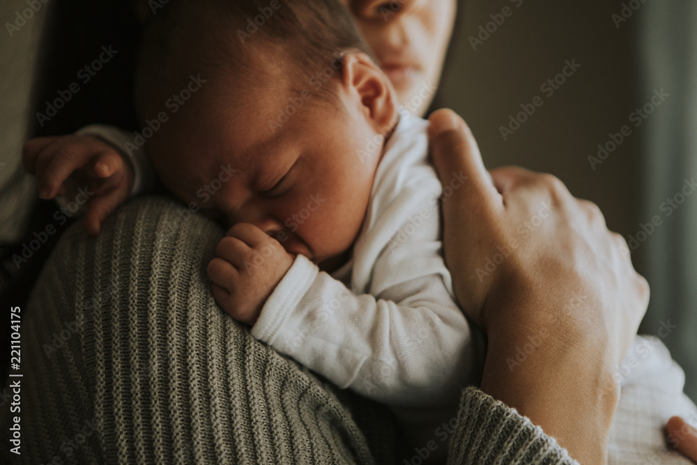 Wall mural mother holding her baby indoors